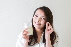 サプリメントを飲料する女性